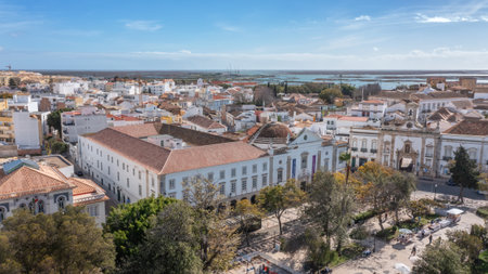Traditional Portuguese town of Faro on oceanfront with old architecture, filmed by drone. Arco de...
