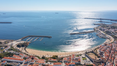 sines portugal. coastal scene panorama, sines harbor and beach view, bright sunlight illuminating seaside townscape, panoramic shot of coastal harbor with sandy beachesの写真素材