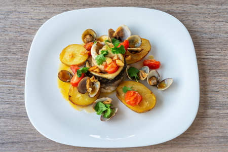 Delicious seafood dish featuring tender fish fillet, roasted potatoes, and fresh vegetables,...