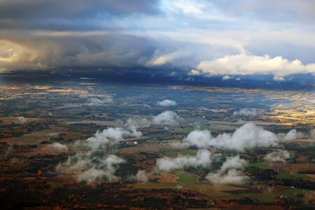view from above on rare clouds floating over forests and meadows against the backdrop of a beautiful...