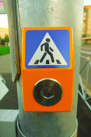 a button on a traffic light pole to turn on a permitting traffic light signal for pedestrians to...