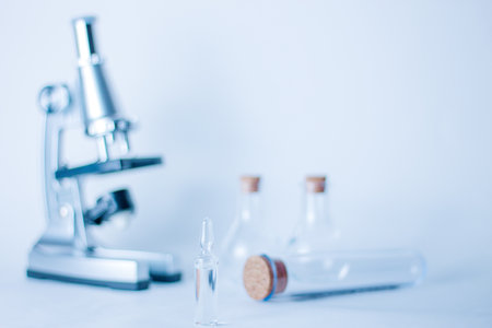 Ampoule with vaccine on the table in the laboratory with flasks and a microscopeの写真素材