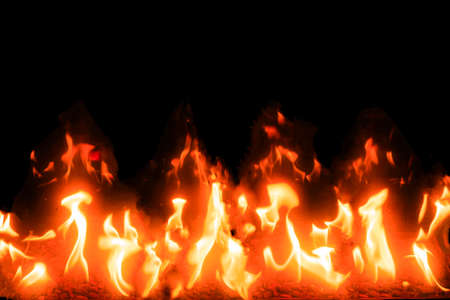 Bright tongues of flame burning in the darkness of the night on the stones