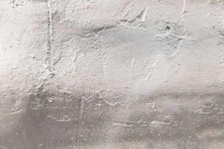 background image: old textured cement wall painted with silver paintの写真素材