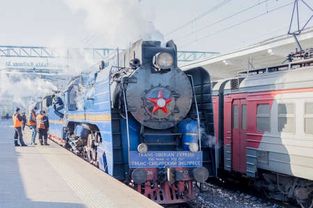 March 27, 2022. Russia, St. Petersburg, A smoking blue retro steam locomotive with the inscription...