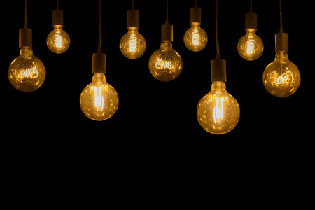 LOVE, ENJOY, DREAM glowing words inside electric glass retro lamps isolated on black background
