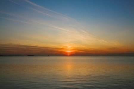 Evening seascape: Setting sun over a calm sea surfaceの写真素材