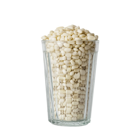Pine nuts in a transparent faceted glass isolated on a white backgroundの写真素材