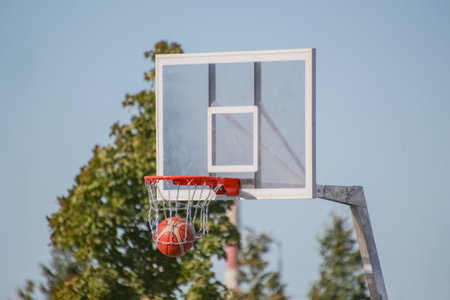 a ball thrown into a basketball hoop with a metal net