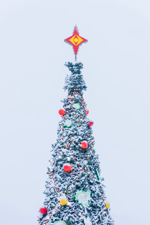 snow-covered fir tree decorated with toys and garlands for Christmas