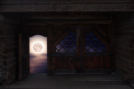 View of full moon in clouds through open door in wooden gateの写真素材