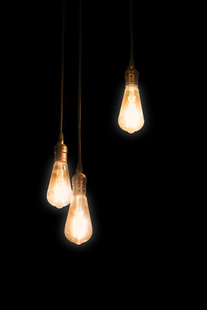 three retro lamps hanging from above with glowing electric lightの写真素材