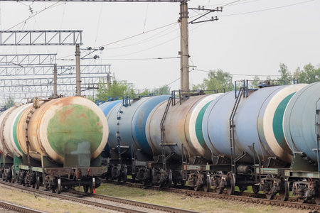 Freight trains of fuel tanks at a railway station under cloudy skies