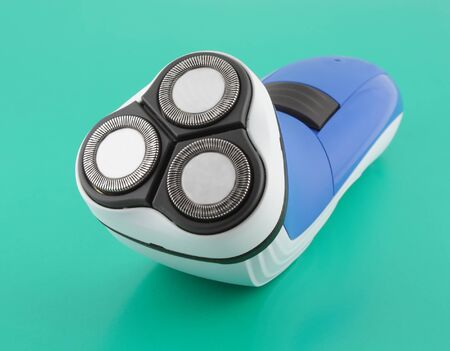 Shaver, blue color. Green background.の写真素材
