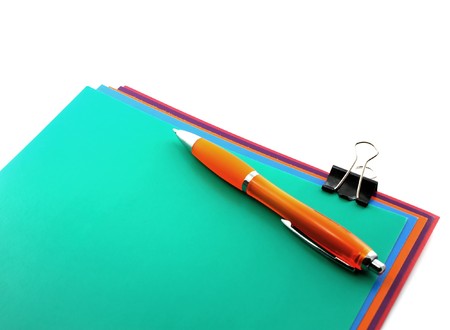 Color papers, black clip and orange penの写真素材