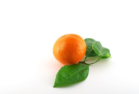 Ripe fresh mandarine with green leaves over whiteの写真素材