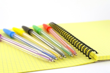 Color pens on the yellow writing-book. Shallow DOF.の写真素材