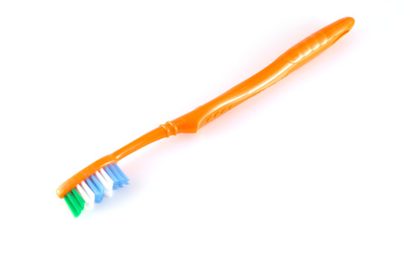 Orange toothbrush over whiteの写真素材