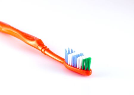 Orange toothbrush over whiteの写真素材