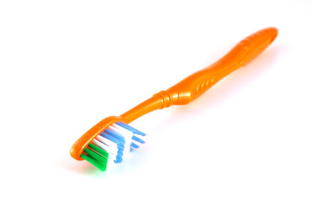 Orange toothbrush over whiteの写真素材