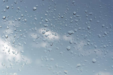 Abstract background, water drops on a window glass, rainy day