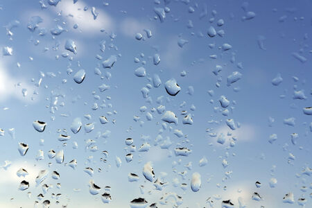 Abstract background, water drops on a window glass, rainy dayの写真素材