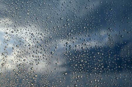 Drops of rain on the window, rainy day, dark tone.の写真素材