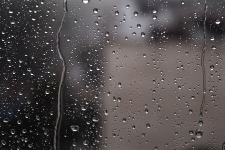 Drops of rain on the window, rainy day, dark tone. Shallow DOFの写真素材