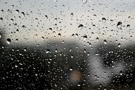 Drops of rain on the window, rainy day, dark tone. Shallow DOFの写真素材
