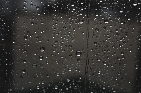 Drops of rain on the window, rainy day, dark tone. Shallow DOFの写真素材