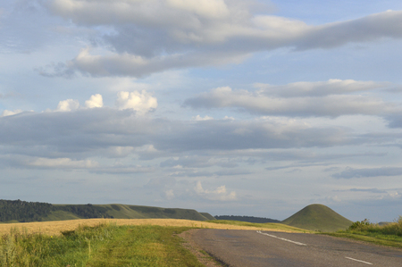 summer landscape with road, mountain and blue sky with cloudsの写真素材