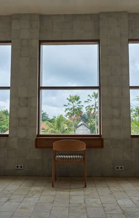 Workplace with chair to internet cafe overlooking palm trees and sky.