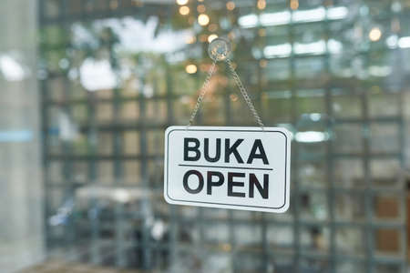 Sign on the glass door of the clothing store - (open) with free space for writing.