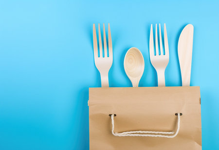 Eco-friendly kitchen utensil set - wooden spoons and forks wrapped in a reusable bagの素材