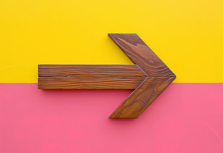 Wooden arrow icon on a bright two-color background, symbolizing direction, progress and navigationの素材