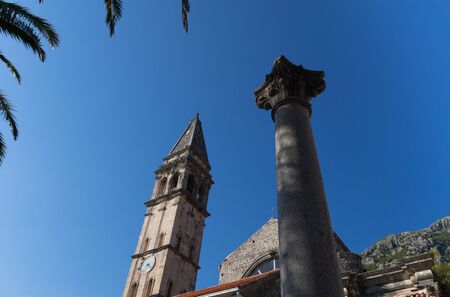 Perast. Building. Montenegro. The bell tower of the Catholic Church and the remains of an ancient Roman column.の写真素材