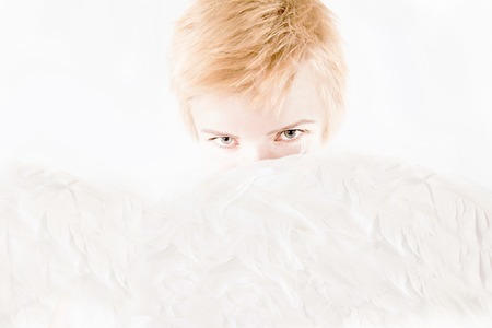 Portrait Of Young Beautiful Blonde Woman. Half Face Covered With Angel Wingsの写真素材