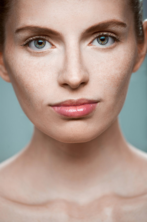 Close-up portrait of sexy beautiful young woman on blue backgroundの写真素材