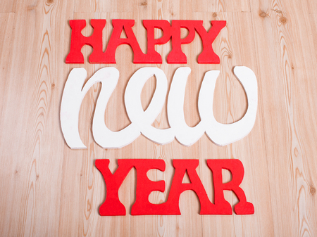 wooden figures happy new year on the wooden background, represents the new year 2016