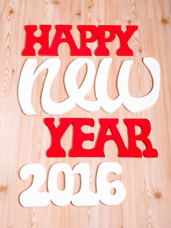 wooden figures happy new year on the wooden background, represents the new year 2016の写真素材