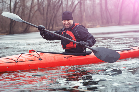 man kayak is on a frozen riverの写真素材