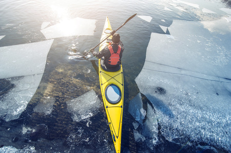 man kayak is on a frozen riverの写真素材
