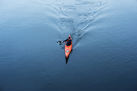 kayaking in cold and rainy weather near the shoreの写真素材