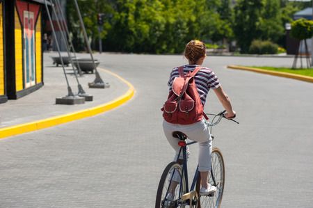 young woman on the bicycle outdoors in cityの写真素材