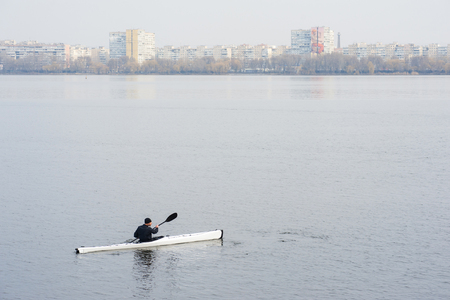 A man in a white kayak near the city riverbank03の写真素材