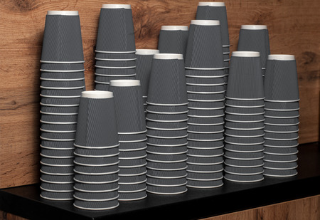grey disposable paper cups on wooden backgroundの写真素材