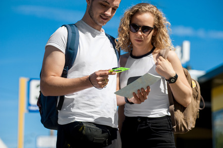 Young couple planning vacation trip with map. Side view close up.の写真素材