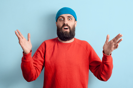 Pleasant surprise concept. Attractive man dressed in youth casual style enthusiastically raising his hands expressing joyful wonderの写真素材