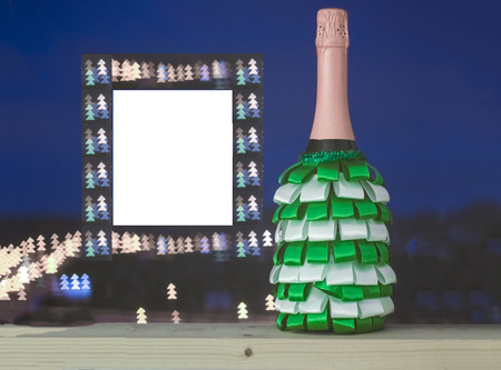 a bottle of champagne decorated with ribbons of green and white against the sky and unusual bokeh.の写真素材