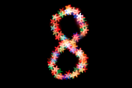 created figure 8 from a colorful bokeh on a black background.International women's day.March 8.